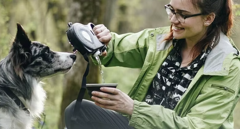 woman giving water to her dog using the dog leash portable bottle