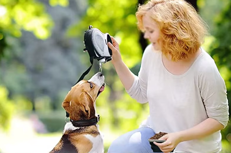 woman giving water to her dog using the dog leash portable bottle