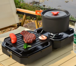 Double portable and foldable gas stove cooking steak on plate and another food on the other part with a pan