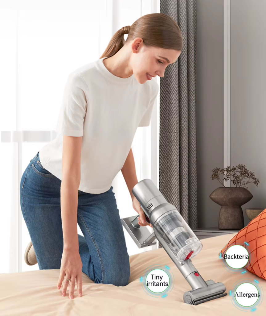 woman cleaning the bed with portable vacuum cleaner